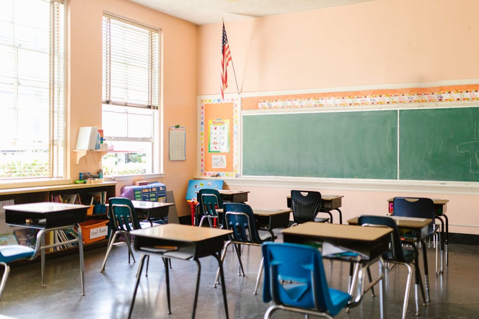 An inviting, sunlit classroom with empty desks and an American flag, ready for students